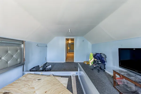 a bedroom with a bed and flat tv screen on the dresser