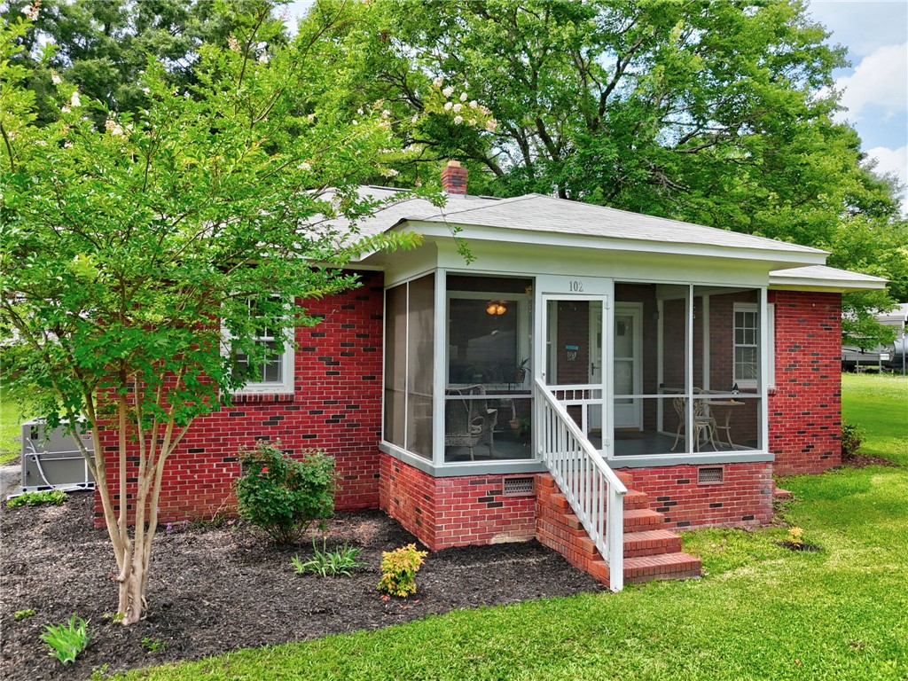 102 Graham Honea Path, SC 29654 - Photo 1 of 29 A charming brick home welcomes with a relaxing screened-in porch and verdant landscaping.