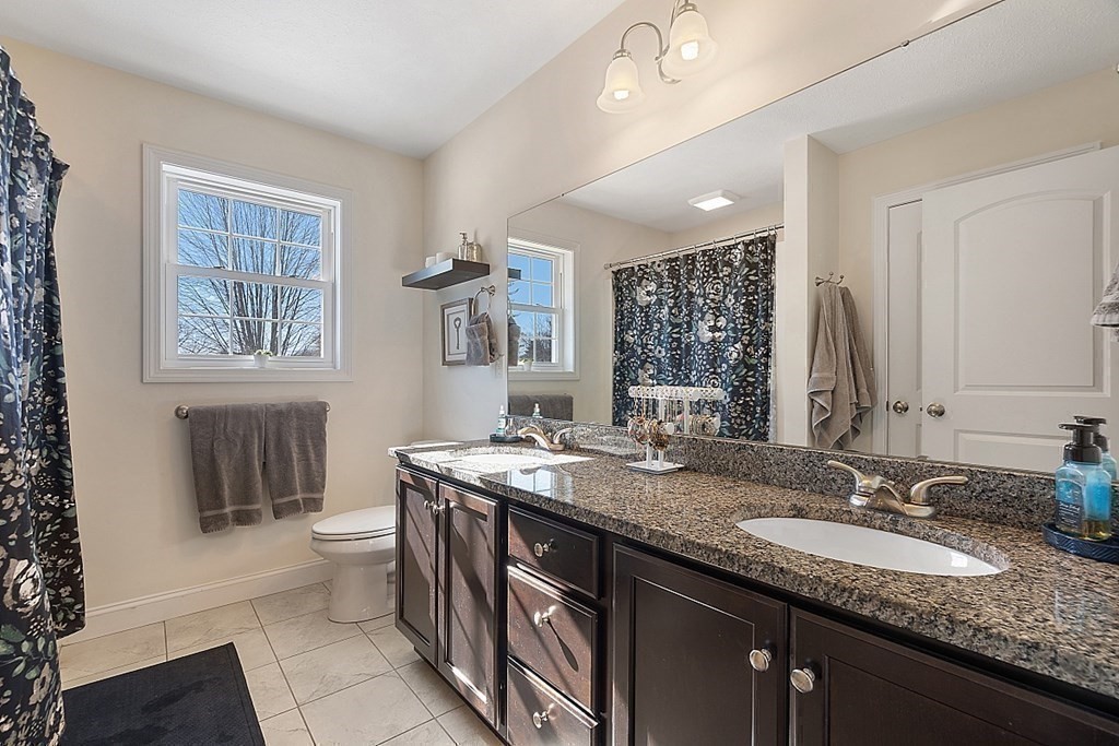 21 Butternut Road Dracut, MA 01826 - Photo 20 of 28 a bathroom with a granite countertop double vanity sink a toilet and a window