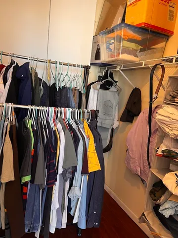 a view of walk in closet with clothes and shoes