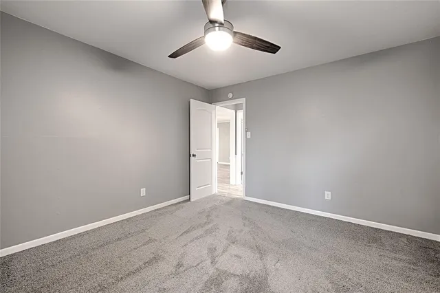 a view of an empty room and chandelier fan