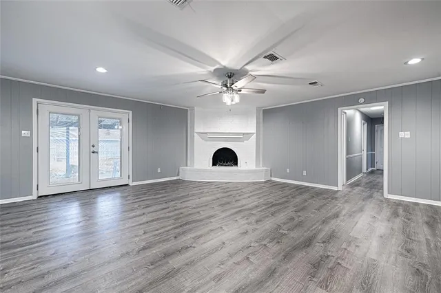 a view of an empty room with a fireplace and wooden floor