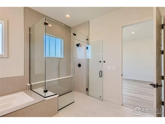 a spacious bathroom with a tub sink and mirror