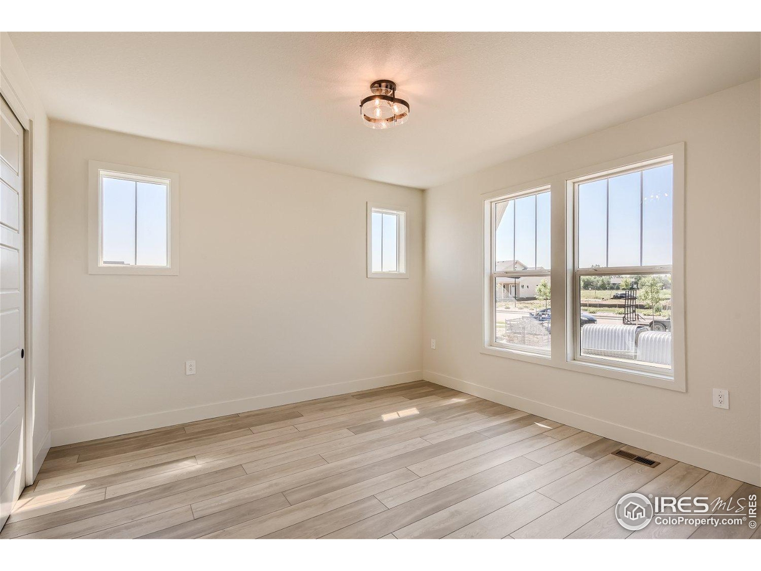 1726 Morningstar Way Fort Collins, CO 80524 - Photo 17 of 29 a view of an empty room with wooden floor and a window