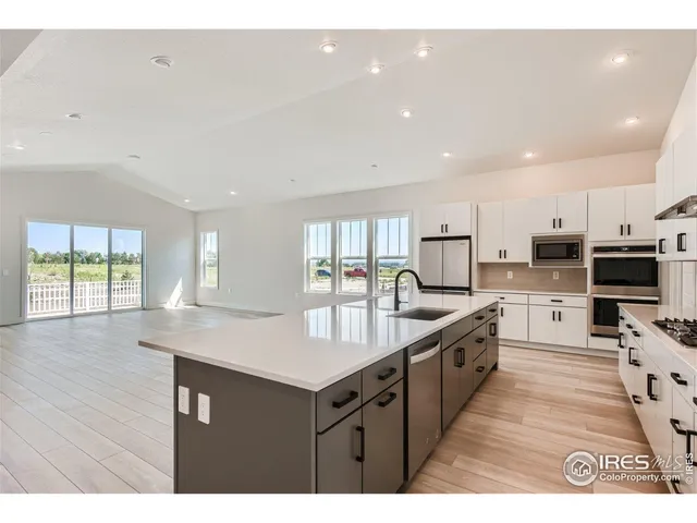 a kitchen with a sink a stove a refrigerator and white cabinets