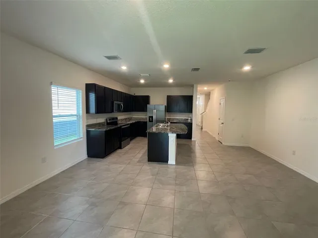 a kitchen with stainless steel appliances granite countertop a sink counter space cabinets and a window