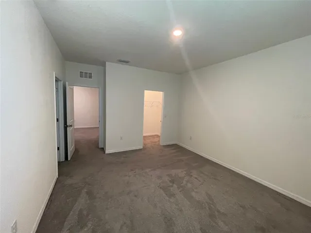 an empty room with closet and a bathroom