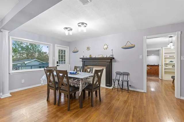 a kitchen with stainless steel appliances granite countertop a table chairs sink and cabinets