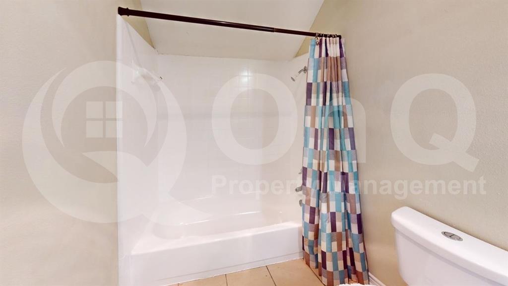 3005 Meandering Way Bedford, TX 76021 - Photo 10 of 24 White shower-over-tub combination with a dark metal shower rod