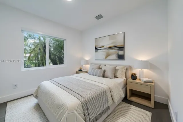 a bedroom with a bed and a painting on the wall