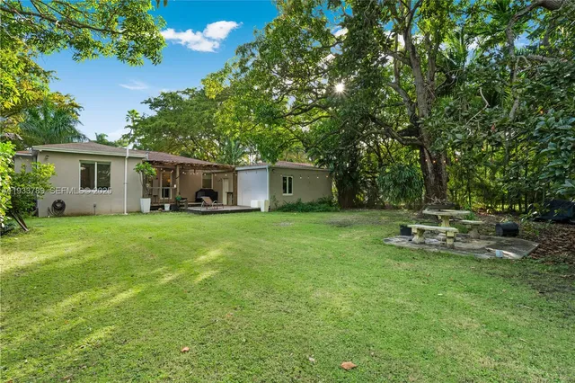 a view of a house with backyard and sitting area