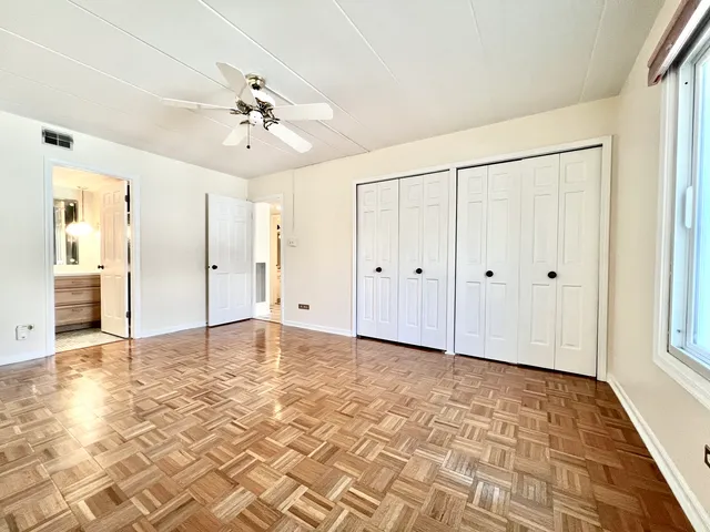 a view of a livingroom with wooden floor and ceiling fan