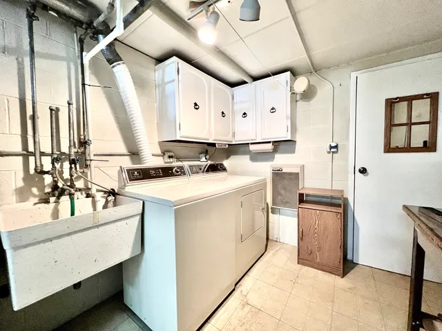 a kitchen with a sink appliances cabinets and furniture