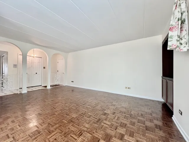 a view of empty room with wooden floor