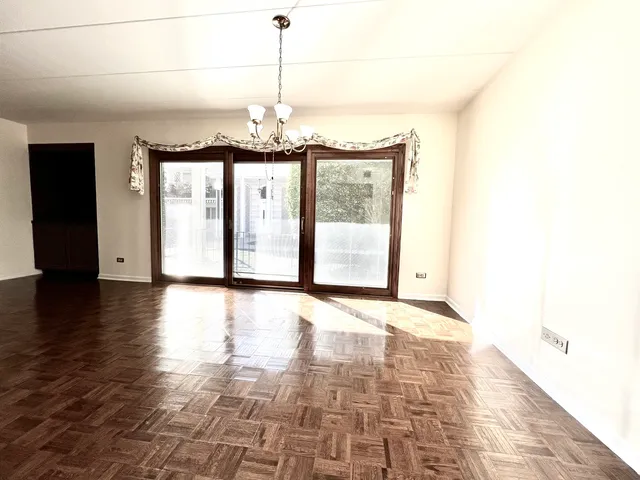a view of a room with wooden floor and large windows