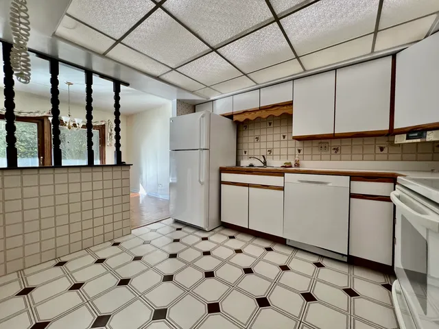 a kitchen with a sink a stove a refrigerator and cabinets