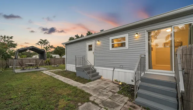 a view of kitchen with stainless steel appliances granite countertop a refrigerator a stove top oven a sink dishwasher and wooden floor