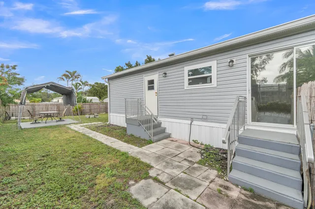 a kitchen with a refrigerator a stove top oven a sink and dishwasher with wooden floor