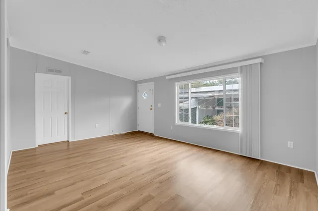 a view of empty room with wooden floor