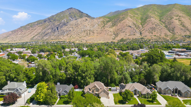 883 East 700 South Springville, UT 84663 - Photo 52 of 59 Aerial perspective showcasing a residential street with mature trees and a distant mountain backdrop