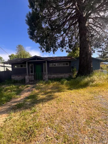 a view of a house with a yard balcony and tree