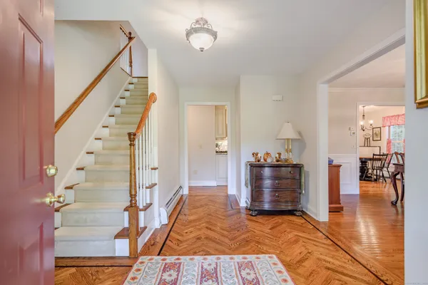 a view of a hallway with wooden floor and staircase