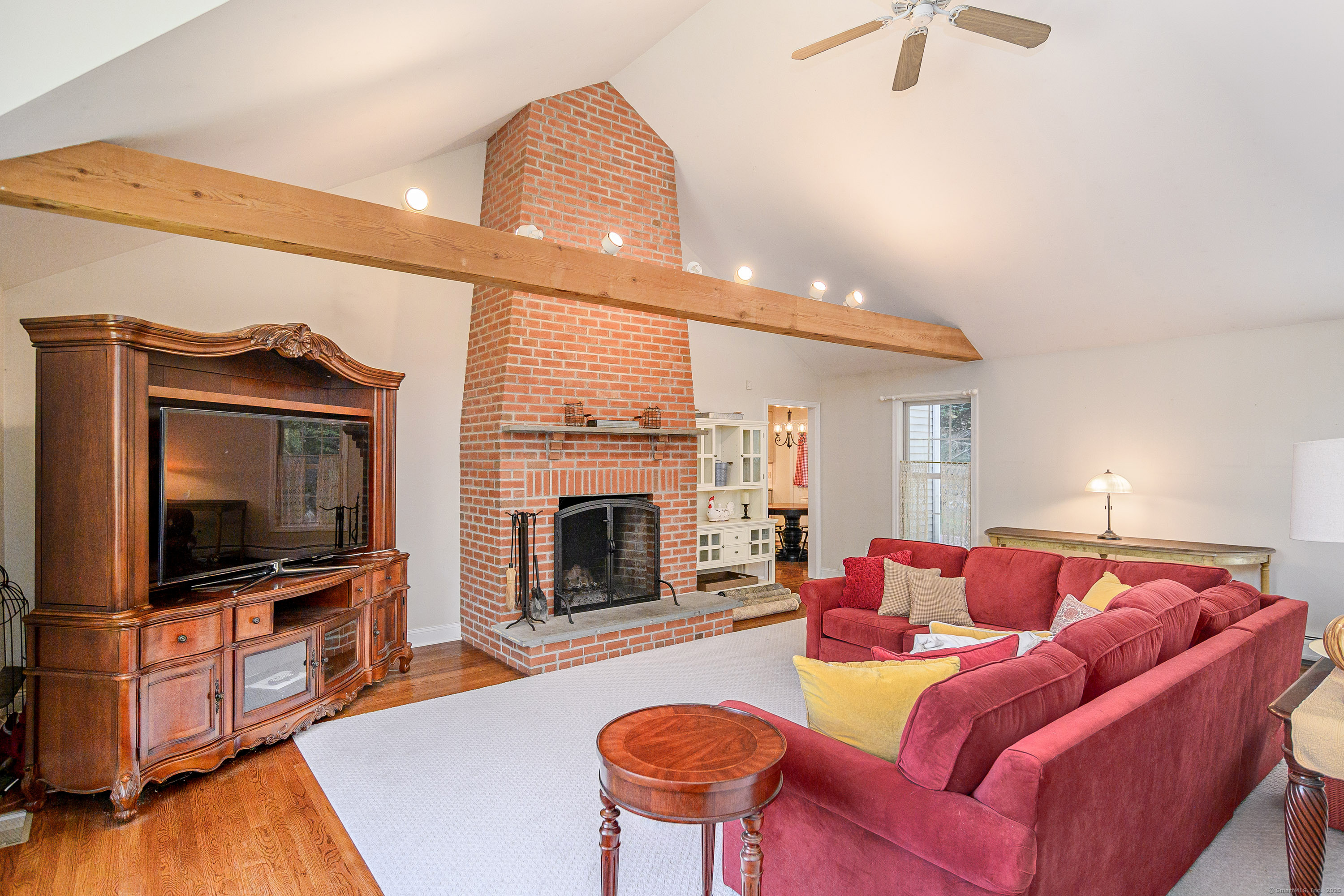 27 Pole Bridge Road Newtown, CT 06482 - Photo 17 of 39 a living room with furniture a flat screen tv and a fireplace