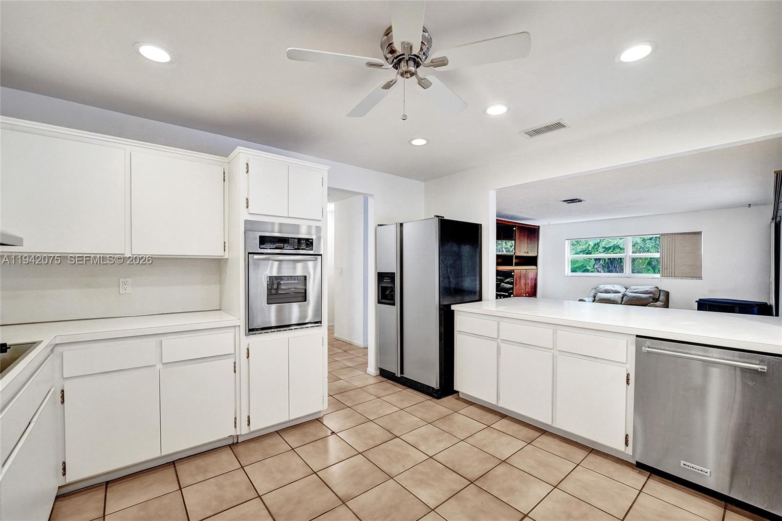 7420 Southwest 13th Street Plantation, FL 33317 - Photo 18 of 68 a kitchen with white cabinets and stainless steel appliances
