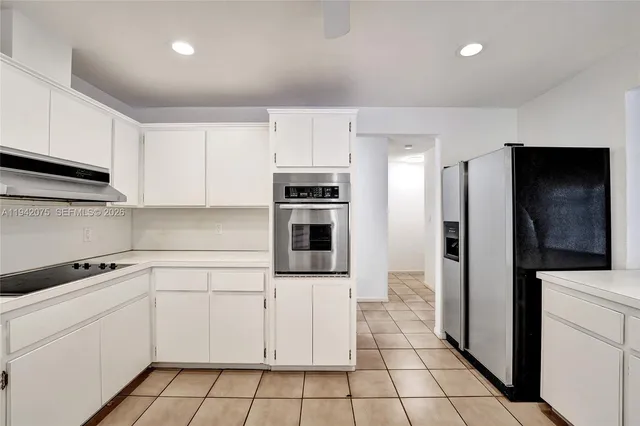 a kitchen with white cabinets a sink and white appliances