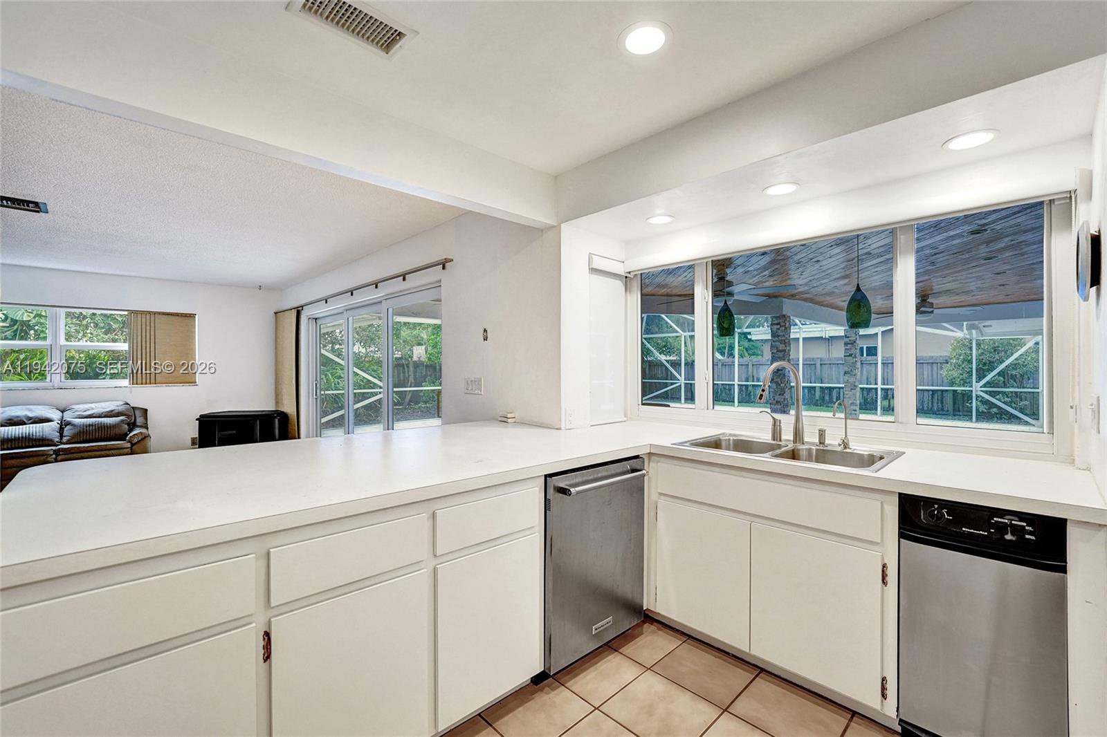 7420 Southwest 13th Street Plantation, FL 33317 - Photo 23 of 68 a kitchen with a sink stove and cabinets