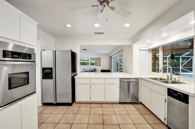 a kitchen with granite countertop a refrigerator and a stove top oven