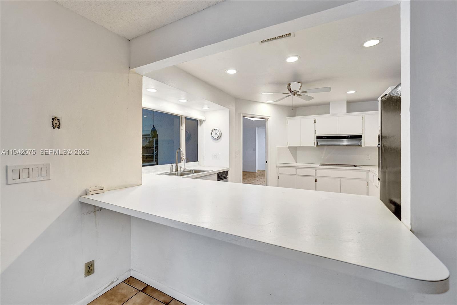 7420 Southwest 13th Street Plantation, FL 33317 - Photo 25 of 68 a large white kitchen with a large counter top appliances and cabinets