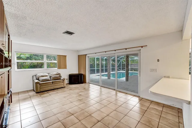 a view of a room with a ceiling fan and a window