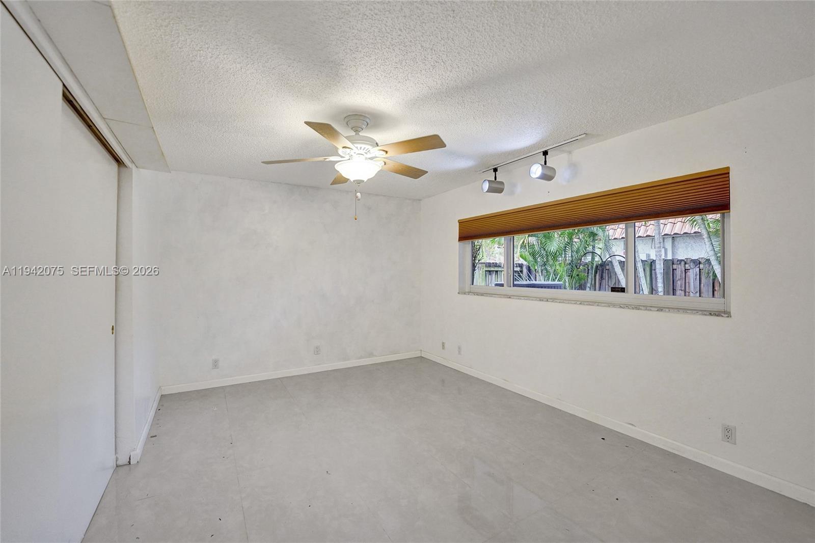 7420 Southwest 13th Street Plantation, FL 33317 - Photo 32 of 68 an empty room with windows and chandelier fan