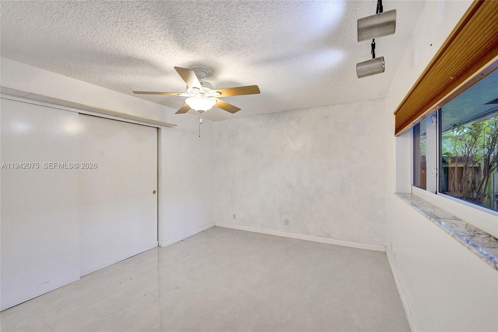 7420 Southwest 13th Street Plantation, FL 33317 - Photo 33 of 68 a view of a room with a ceiling fan and a window