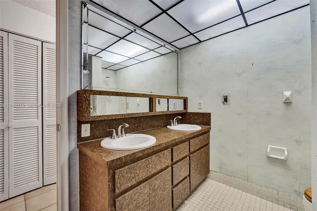 an empty room with windows and chandelier fan