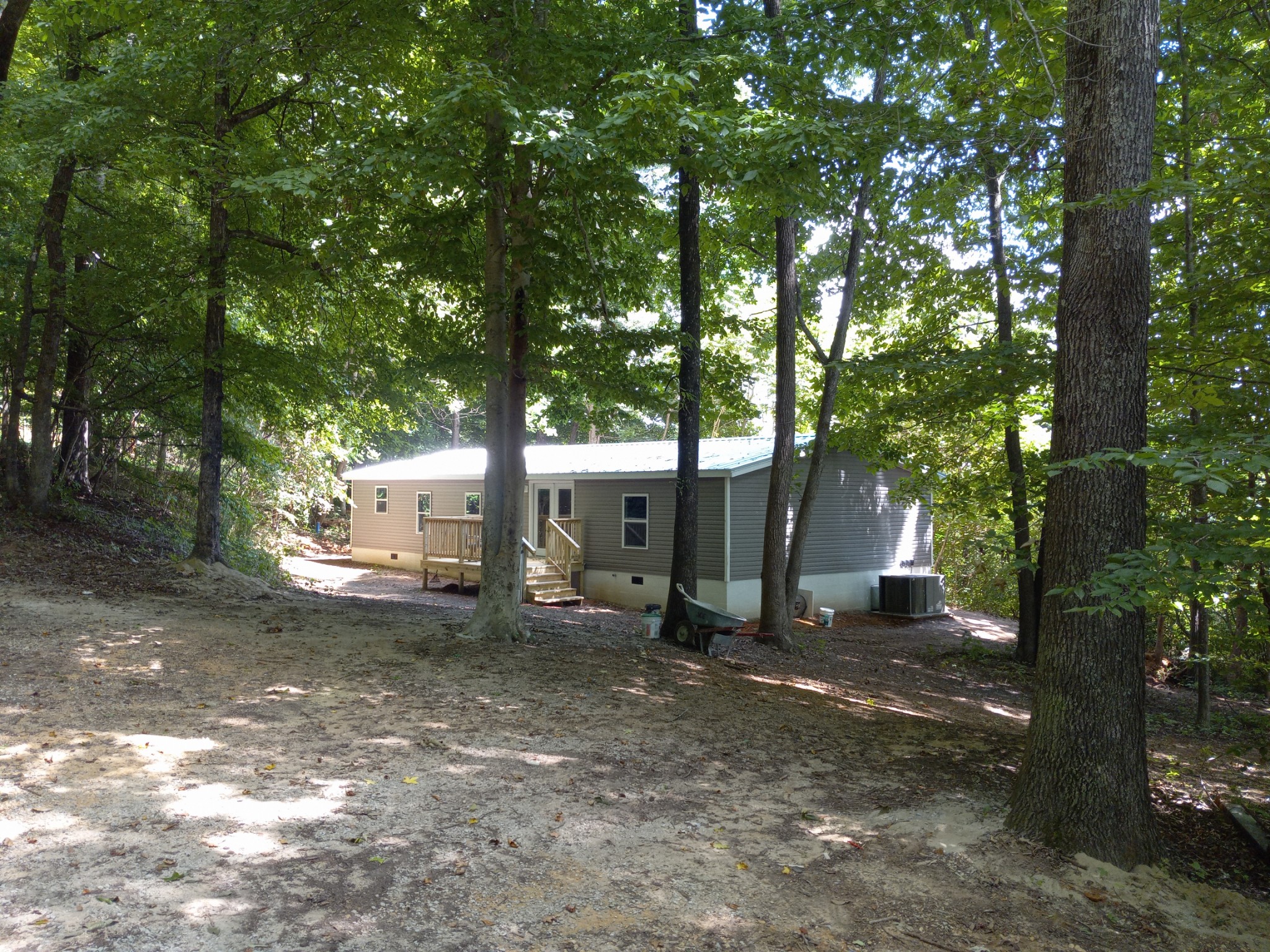 a view of a house with large tree and wooden fence