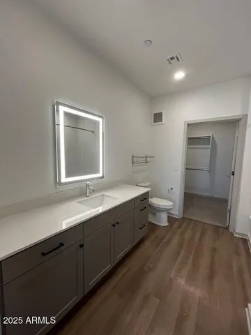 a bathroom with a sink mirror and a toilet