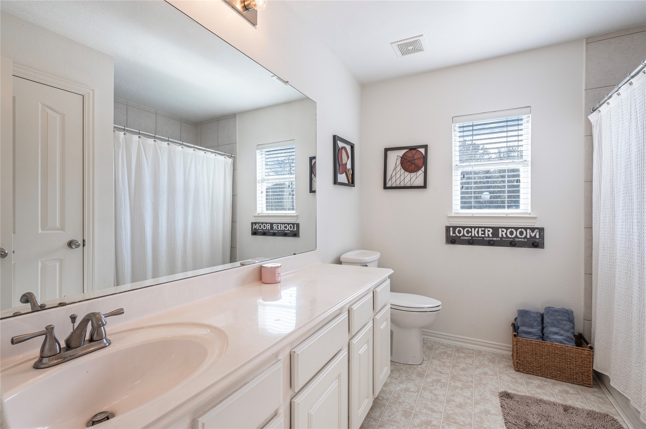 700 Red Oak Lane Friendswood, TX 77546 - Photo 36 of 48 a bathroom with a sink a toilet and a large mirror