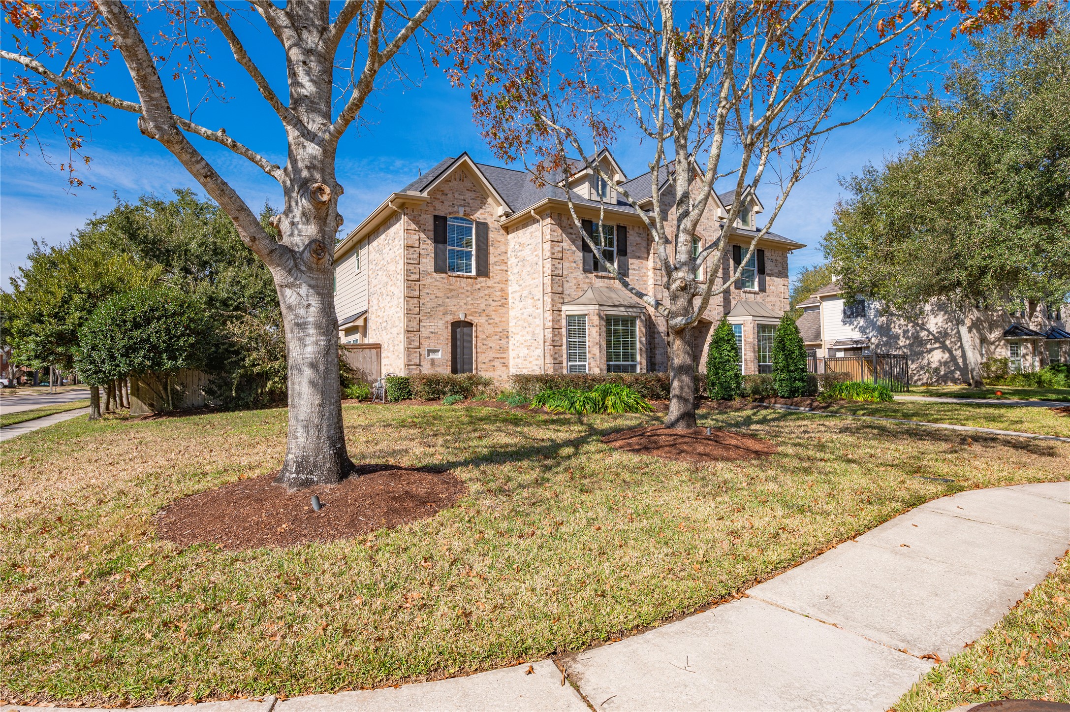 700 Red Oak Lane Friendswood, TX 77546 - Photo 4 of 48 a view of a white house with a yard and large tree