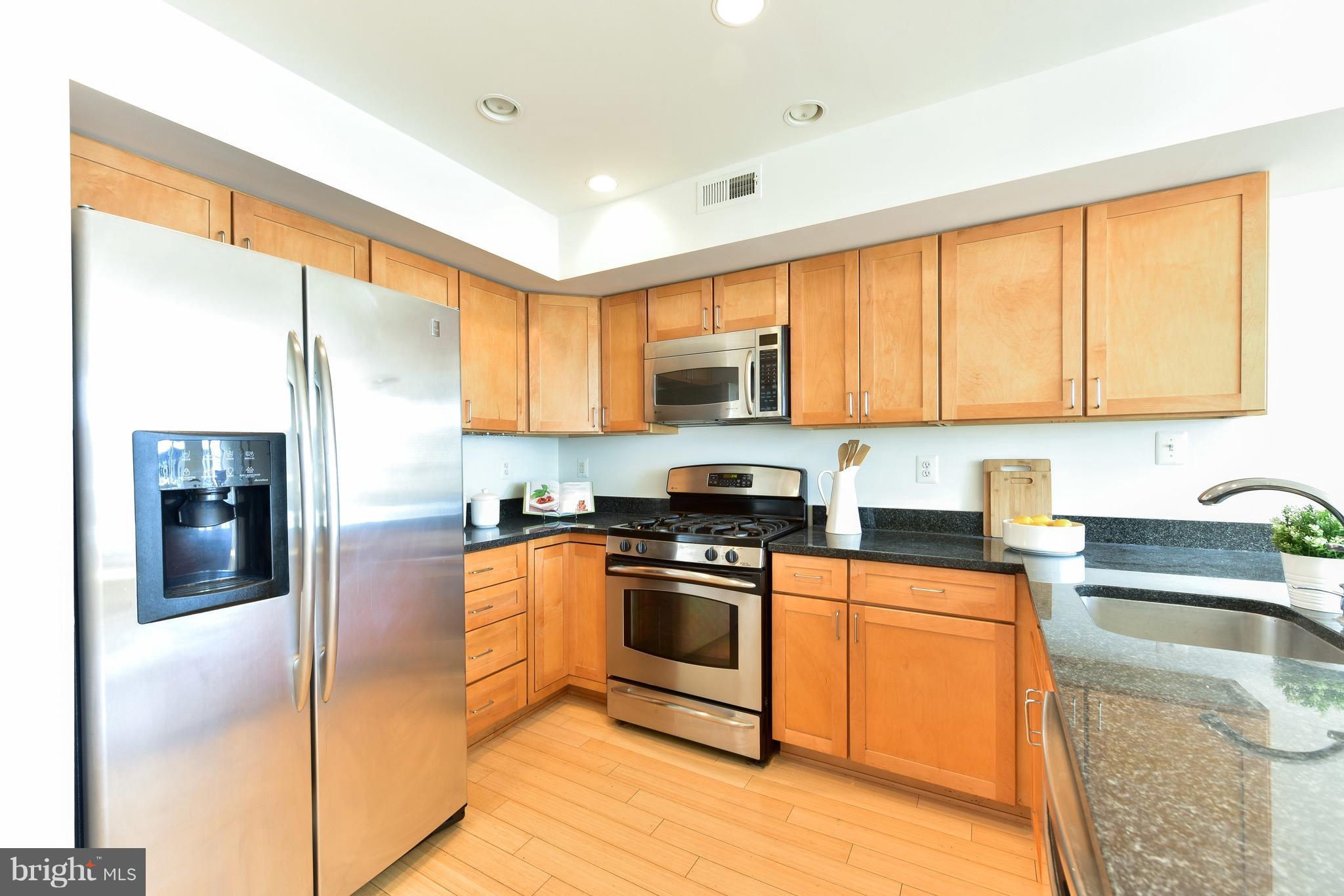2713 Ontario Road Northwest, Unit 4 Washington, DC 20009 - Photo 11 of 25 a kitchen with stainless steel appliances granite countertop a stove top oven a sink and a refrigerator