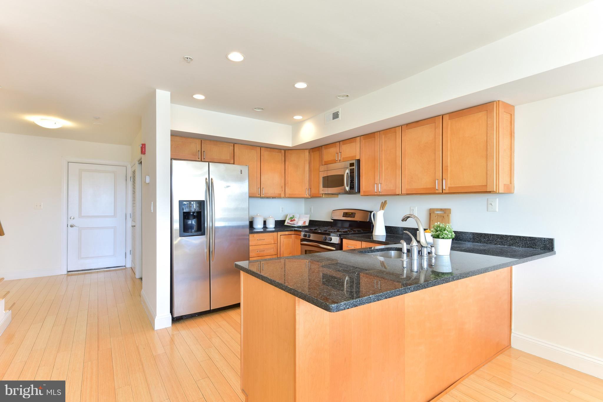 2713 Ontario Road Northwest, Unit 4 Washington, DC 20009 - Photo 7 of 25 a kitchen with stainless steel appliances granite countertop a sink refrigerator and cabinets