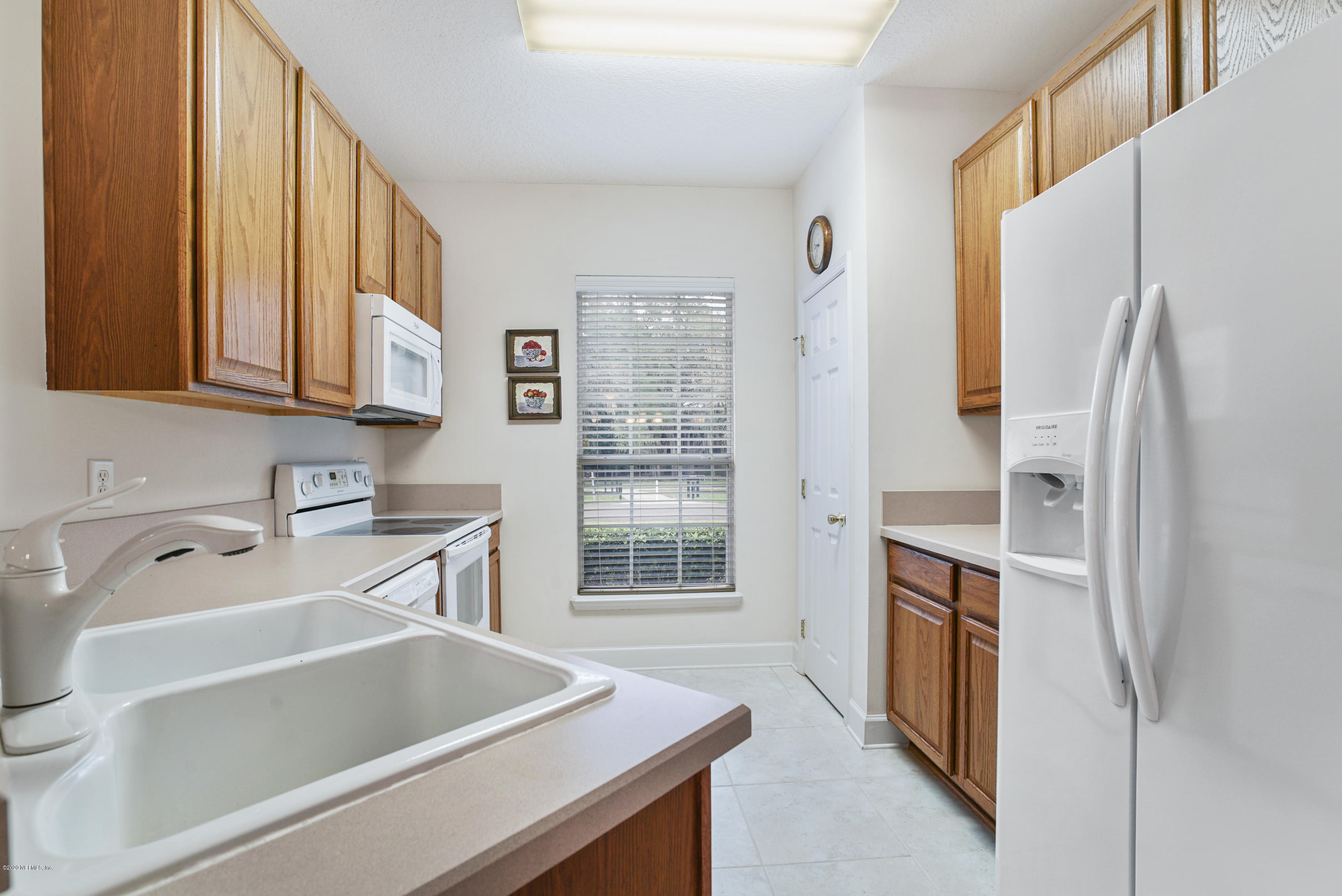 3158 Ravines Road Middleburg, FL 32068 - Photo 11 of 34 a kitchen with a refrigerator and a sink