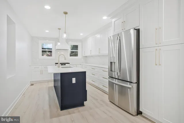 a kitchen with kitchen island white cabinets and stainless steel appliances