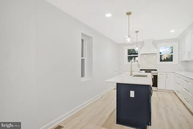 a kitchen with kitchen island a counter top space a sink and appliances