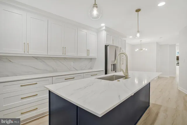 a kitchen with a sink a refrigerator and cabinets