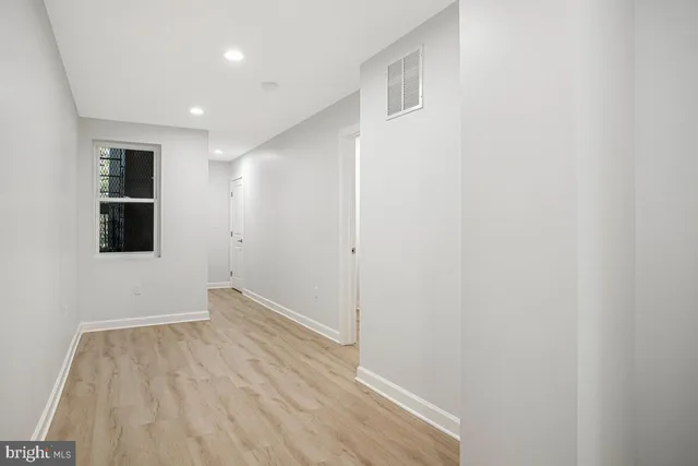 a view of a room with wooden floor and entryway
