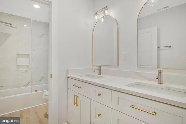 a bathroom with a sink double vanity granite tub and shower