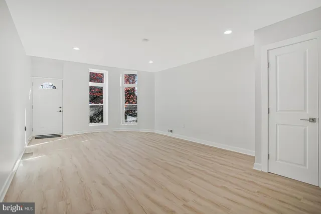 a view of empty room with wooden floor and window