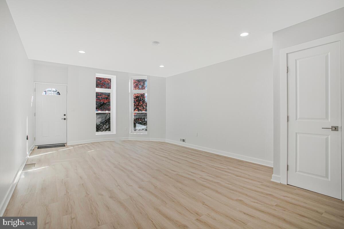 2258 Brookfield Avenue Baltimore, MD 21217 - Photo 5 of 42 a view of empty room with wooden floor and window
